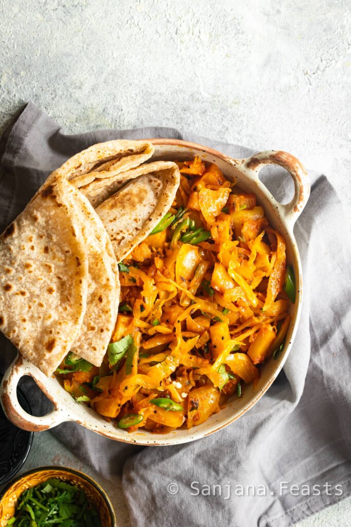 Cabbage and Potato Curry in a bowl with wholemeal roti