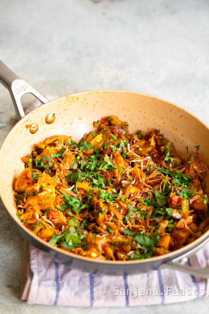 Garnish karela curry with fried onions and coriander