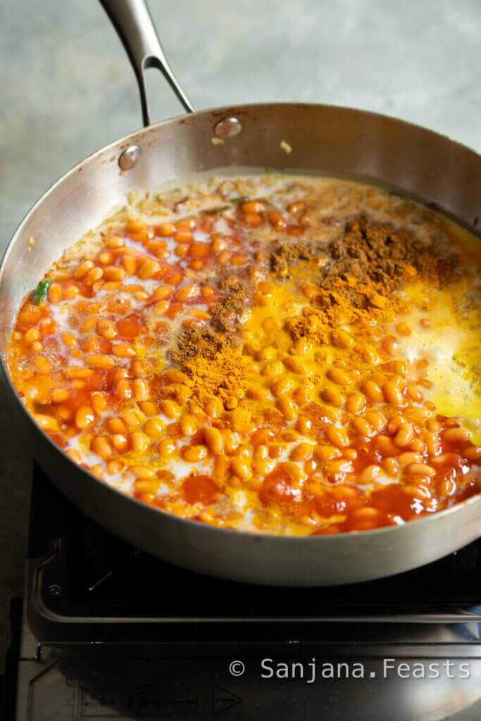 pot of indian masala beans being cooked on the stove with turmeric and garam masala